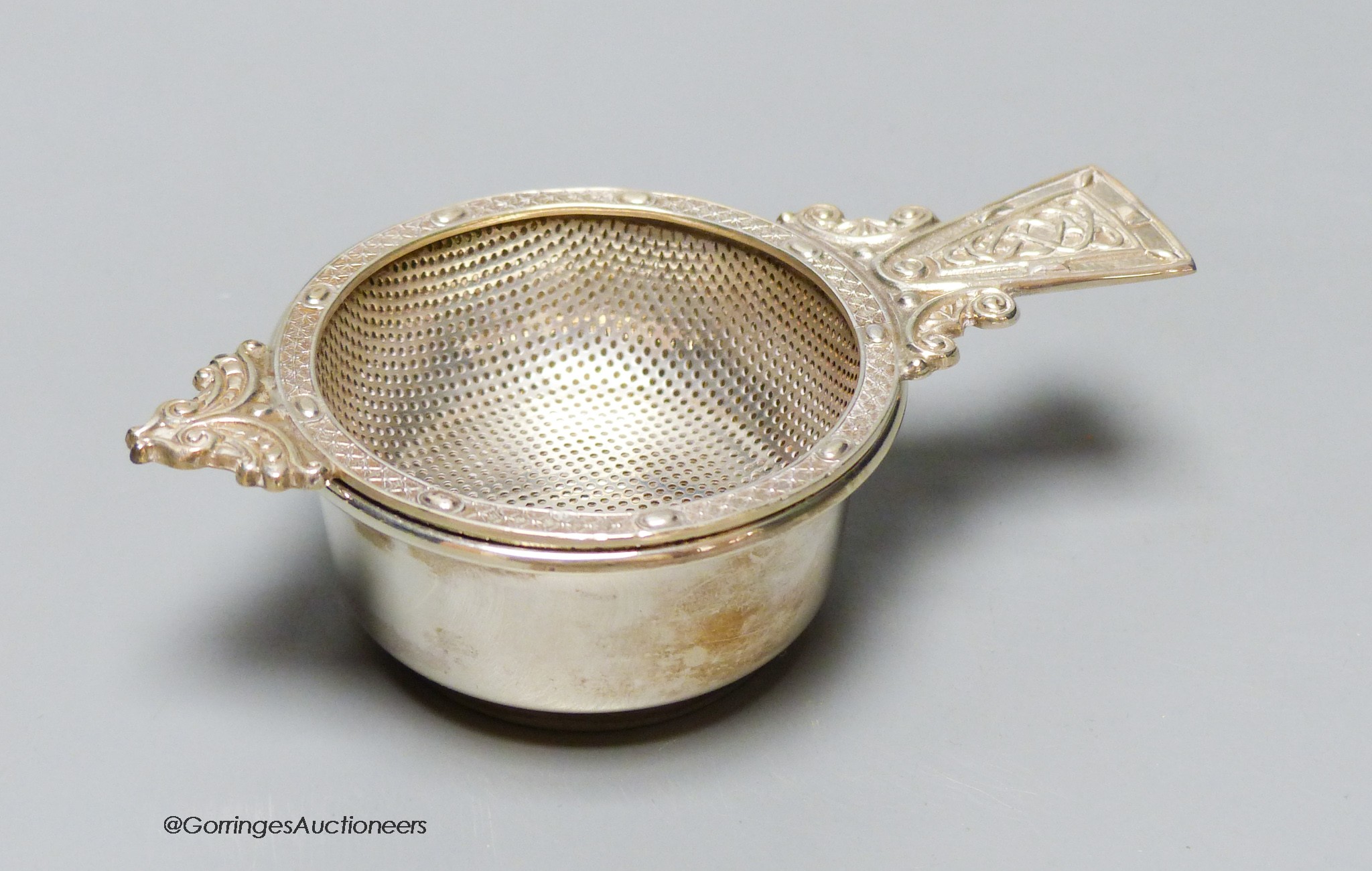 A modern silver tea strainer and stand by A.E. Jones Ltd, Birmingham, 1970, 10.9cm, 74 grams.